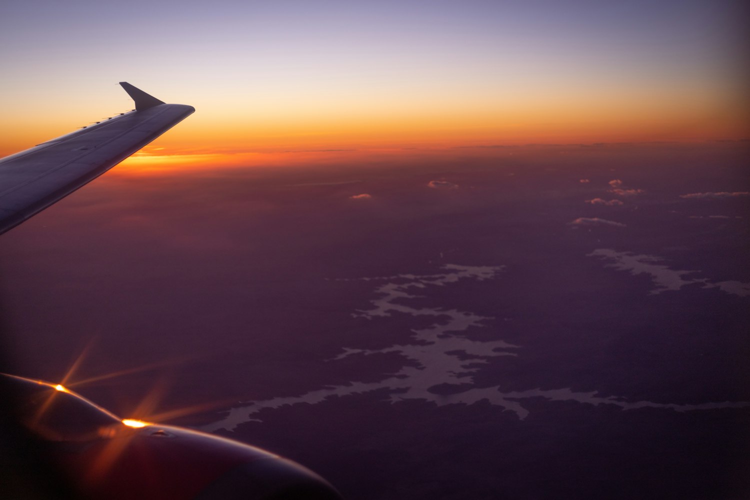 Aircraft wing above the clouds at sunset